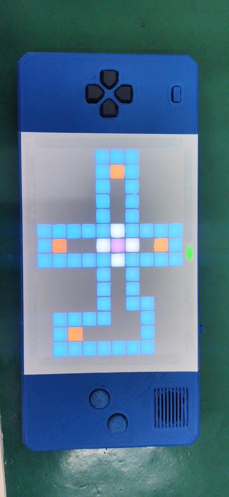 Vertical blue handheld with a grid screen showing a cyan cross-shaped maze with orange squares.